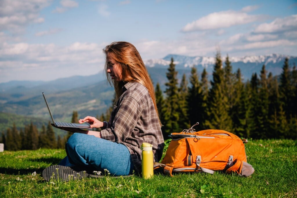 woman working on laptop while hiking