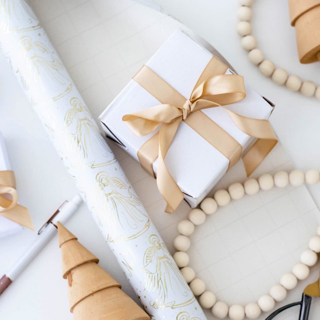 wrapped Christmas gifts with wrapping paper and a pen on a table